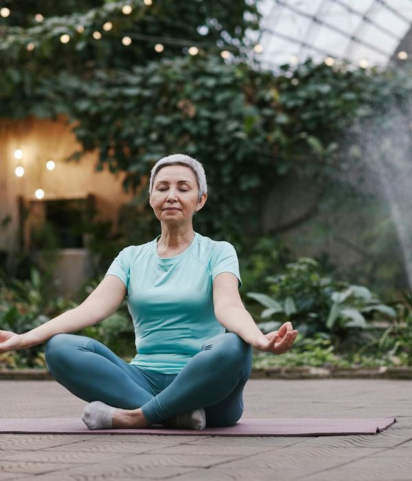 Woman meditating peacefully in a natural setting.